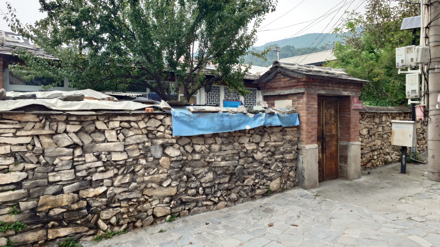 A Nanjiao courtyard entrance set into an irregular dry-stone wall