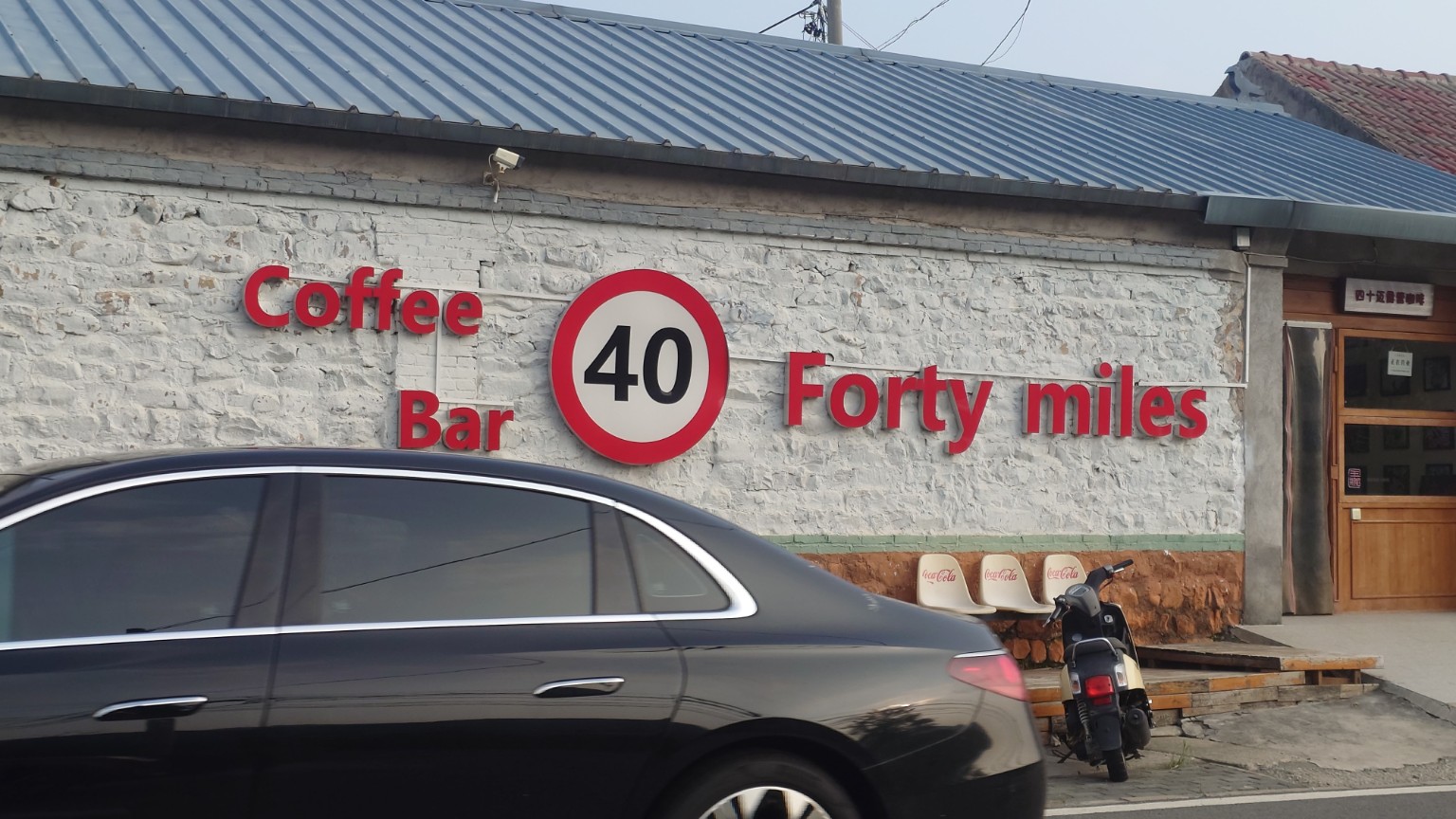 The Forty Miles coffee bar sign on a renovated stone village building